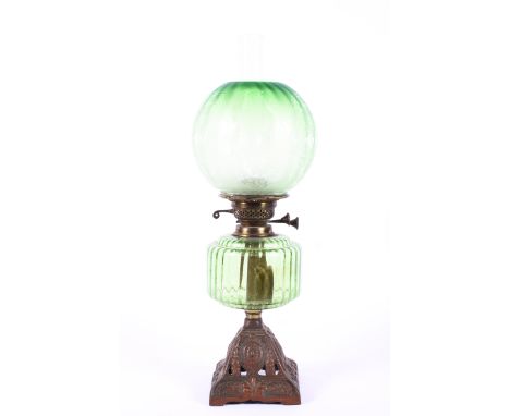 An Edwardian green glass oil lamp, the fluted shade etched with flowerheads and leafy branches, the burner marked British Mad