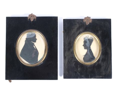 Two portrait silhouttes, 19th century, one depicting a period gentleman, the other a lady in lace bonnet, each mounted in an 
