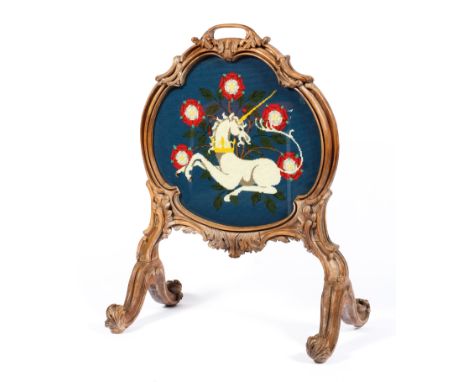 A Victorian carved walnut firescreen, the needlework panel later, the trefoil shaped frame carved with acanthus and scrolls, 