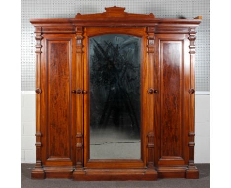 A large Victorian mahogany wardrobe-linen press, of architectural breakfront form, with pediment above four reeded column sup