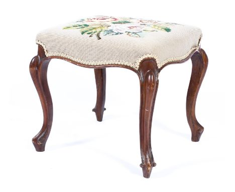 A Victorian needlework stool, of serpentine form, on carved walnut cabriole legs and raised feet, the top with needlework bou