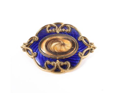 An enamel and yellow metal mourning brooch, the central quartz panel with blue guilloche and gilt metal surround, 22g, 55mm x