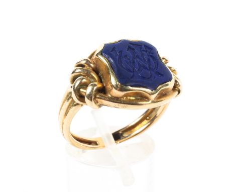 A late 19th century gentleman's unmarked yellow metal signet ring, with Lapis  shield shaped intaglio flanked by knot shoulde