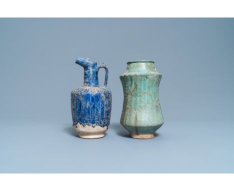 Full title: A turquoise-glazed Islamic pottery albarello and a blue-glazed ewer, Iran or Syria, 12/13th C.Description: H.: 26