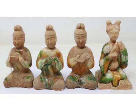 Four Ming Dynasty glazed tomb guardians, each holding musical instruments, losses and repaired damages throughout, largest H: