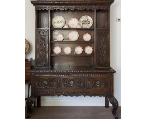 VICTORIAN CARVED OAK DRESSER OF 17TH CENTURY DESIGN 
the leaf carved cornice with open shelves and two upright cupboards belo
