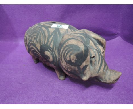 A vintage ceramic pig bank decorated in a native Maori design