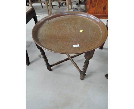 An early 20th Century twist leg folding tray table, having copper tray top