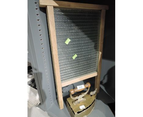 A vintage glass washboard and ornate stove iron 