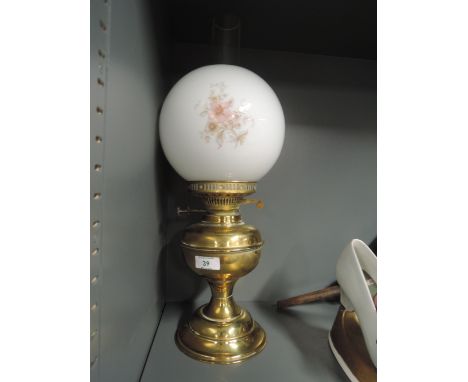 A vintage oil lamp with brass body and printed shade