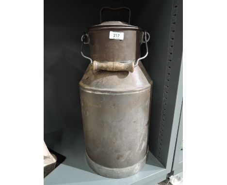 A vintage milk churn with lid and wooden handle