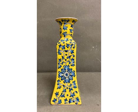 A porcelain Chinese blue, white and yellow candle stick with a floral decoration 