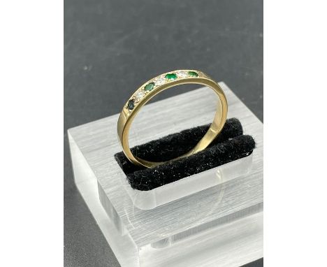An emerald and diamond ring with four sapphire and three diamonds on an untested gold band.  Size X