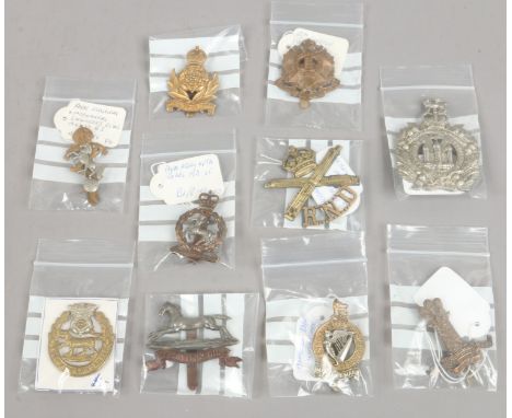 Ten military cap badges including 10th London Hackney regiment, Kings own Scottish Borders, Royal Army Veterinary Corps, 11th