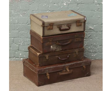 Four vintage suitcases including a leather bound example and one with original paper labels.