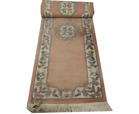 A large wool peach ground runner with floral decoration, 310 x 75cm.