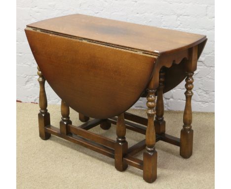 An oak gate leg dining table on turned supports.