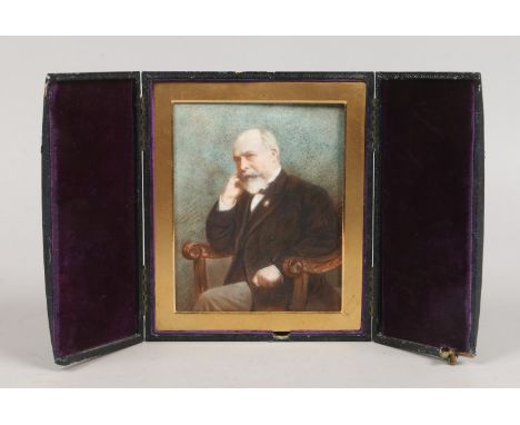 An Edwardian portrait miniature on opaque glass of a seated gentleman in leather strut case.