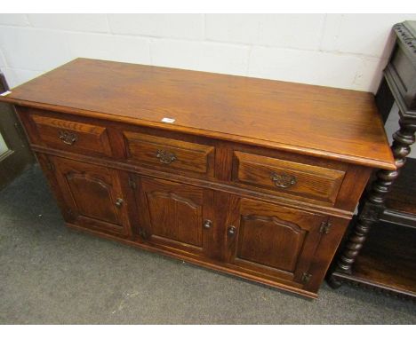 A Multiyork 17th Century style oak dresser base of three drawers over fielded panel three door cupboards. 138cm wide x 80cm t