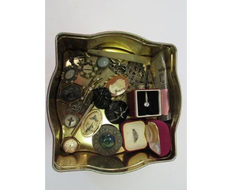 A tin of costume jewellery including cameo brooch, silver ring etc.