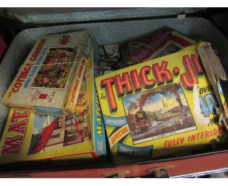 A case of vintage boxed games/jigsaws, with a box of VHS tapes   