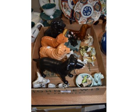 A box of ceramic animal studies, predominantly dog related interest, including novelty items and Wade whimsies.