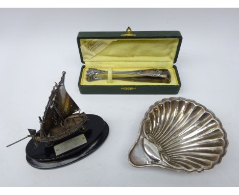 Silver scallop dish by Joseph Gloster Ltd, Birmingham, cased pair of French silver sugar tongs and small silver model of a bo