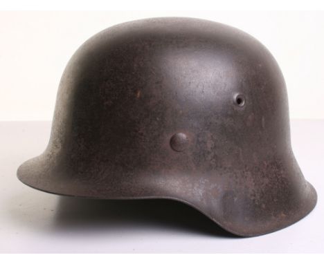 German Army M-42 Steel Combat Helmet, retaining much of its original field paint finish to the exterior. Inside the shell is 