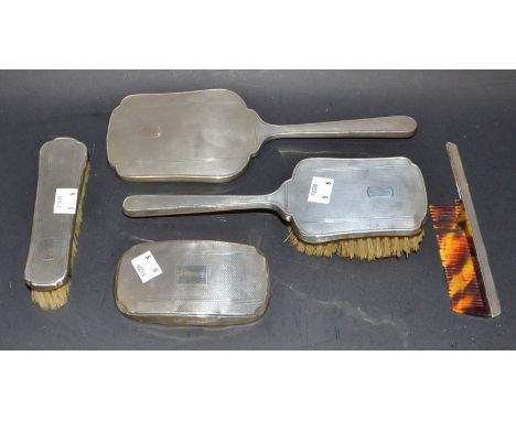 A matched silver five piece dressing table set, comprising hand mirror, clothes brush, hair brush, comb etc, Birmingham 1947 