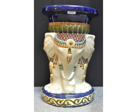 A ceramic jardiniere stand supported by a trio of Indian elephants