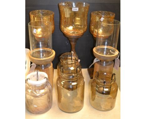 A set of three graduated treen based hurricane lanterns with glass shades; another pair similar;other tea light jar lanterns 