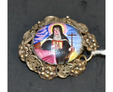 An 18th century oval enamel nun holding a cross, set filigree silver brooch