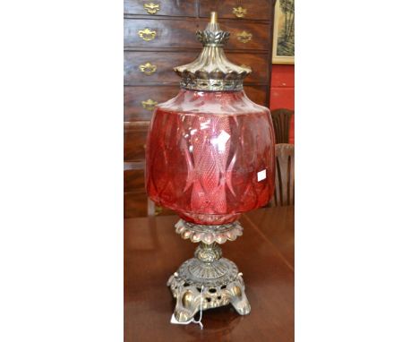 An oil lamp with a large ruby lamp shade, converted into electricity.