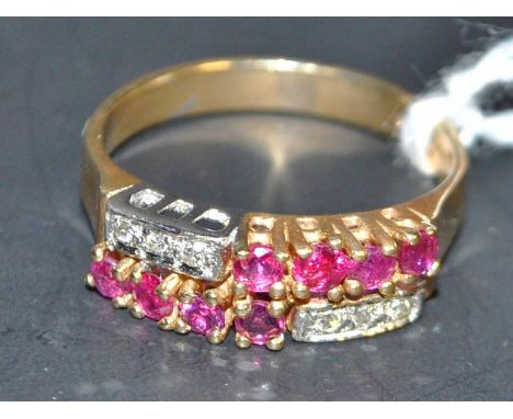 A ruby and diamond cluster ring, rectangular crest inset with eight red ruby's and six round brilliant cut diamonds, arranged