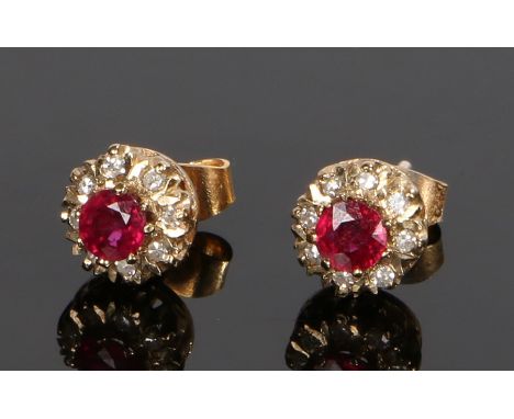 Pair of 9 carat gold ruby set earrings, with central rubies and stone surround forming a flower head, 5mm diameter 