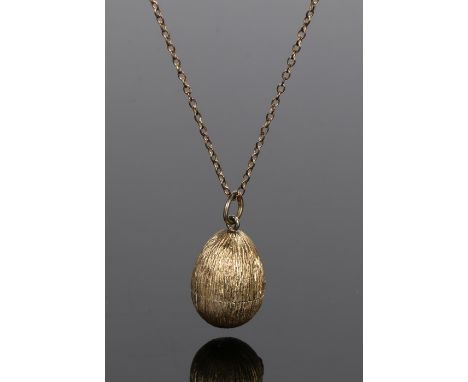 Stuart Devlin (1931 - 2018) Elizabeth II silver-gilt and enamel surprise egg, textured body overall with a middle hinge openi