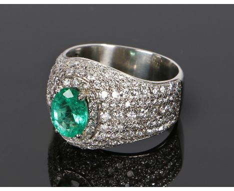 Impressive emerald and diamond set platinum ring, the oval emerald at an estimated 1.58 carat with a surround of diamonds tot