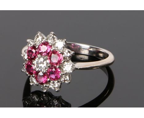 18 carat white gold diamond and ruby set ring, the flower head design with central diamond and a ruby and diamond surround, r