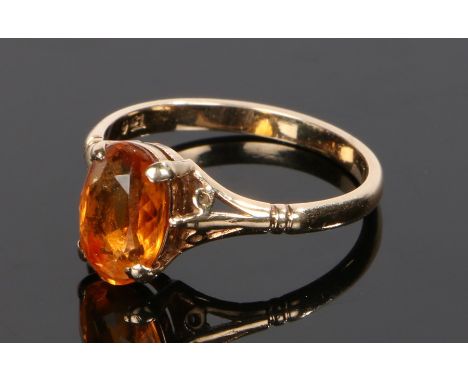 9 carat gold ring, with an oval facetted orange stone, ring size O 1/2