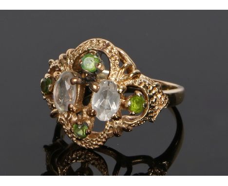Yellow metal ring, set with peridot round cut stones and pale purple stones to the arch design head, ring size L