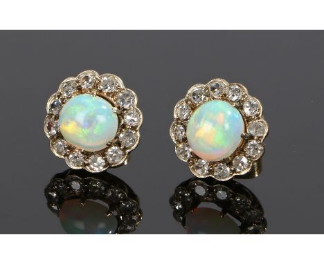 Pair of opal and diamond set earrings, the solid opal held within a claw mount and twelve round cut diamonds surrounding, 13m