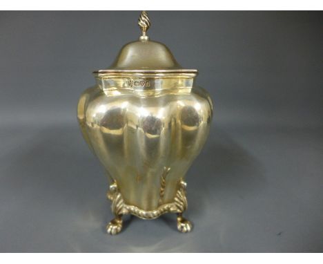 A silver hallmarked tea caddy, finial to top over hinged lid with silver gilt interior, gadrooned pattern to base and raised 