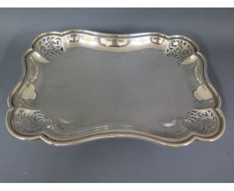 A silver hallmarked tray raised on four swept feet the edges or corners of the tray with pieced decoration, mark for Sheffiel