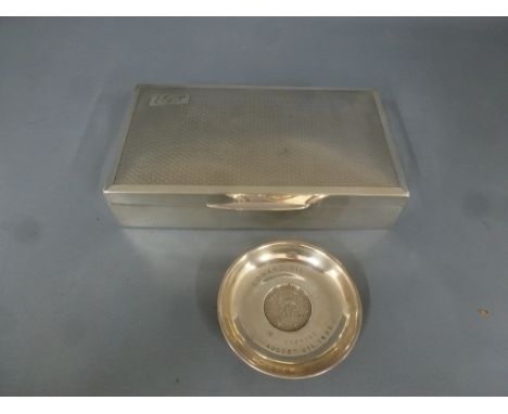 A silver hallmarked cigarette box with hinged lid, decorated with engine turned decoration and initials to top left hand corn