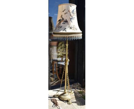 An adjustable brass standard lamp with chinoiserie shade embroidered with two phoenix and stylized clouds
