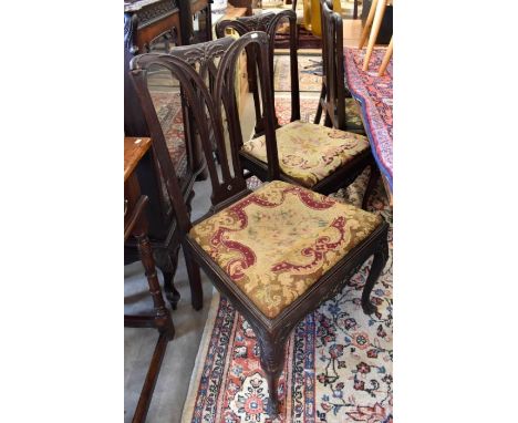 A set of ten Georgian mahogany dining chairs with fret-cut vertical splats and foliate carved rails, non matching tapestry pa