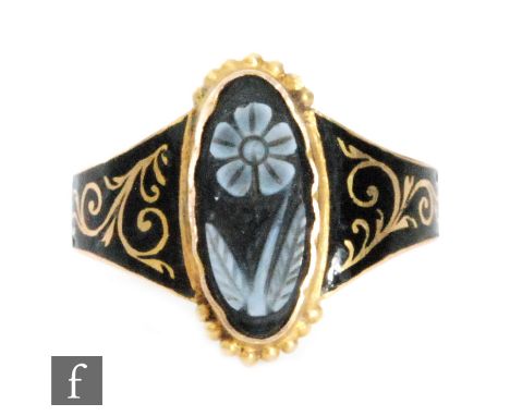 A late 19th Century 18ct memorial ring with In Loving Memory Of picked out of black enamel to shank, a cameo glass single flo