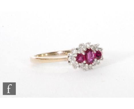 A 9ct hallmarked ruby and diamond cluster ring, three central oval rubies within a diamond set surround, ring size N. 