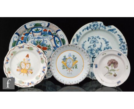 A collection of Delft and tin-glazed plates and charger, to include three French polychrome Quimper examples, with foliate an
