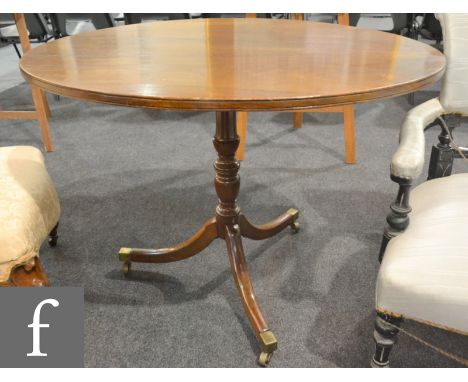 A George IV mahogany snap-top supper table, the later oval-shaped top over a turned support with splayed legs, height 68cm an